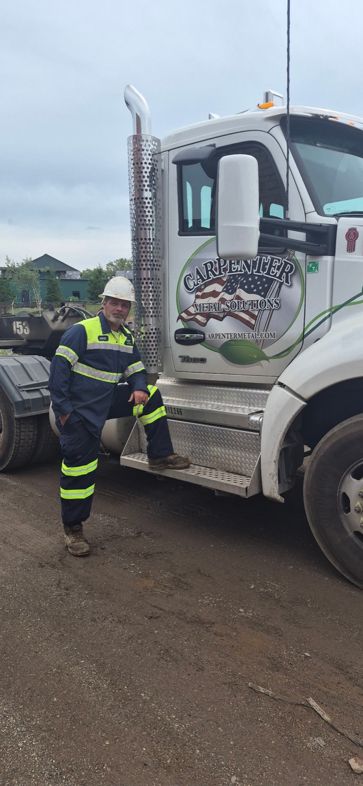 David Dowdy in high-visibility gear beside a Carpenter Metal Solutions truck