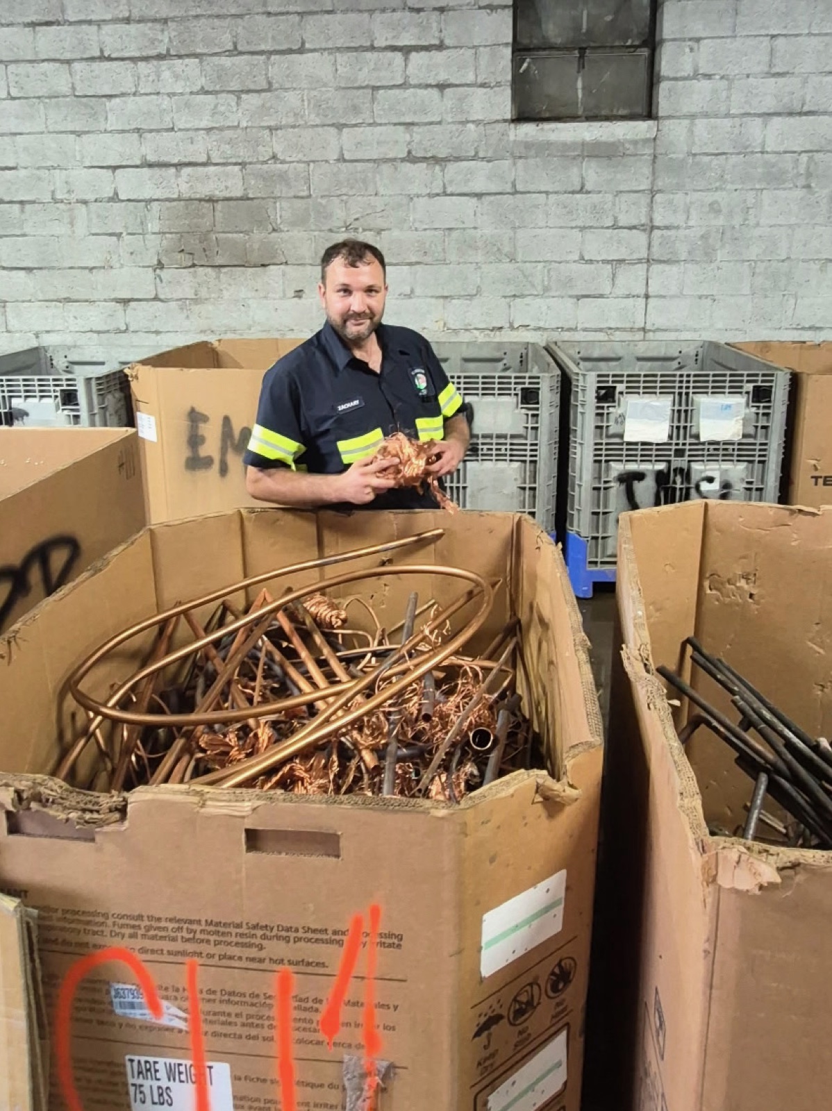 Zach Braho with a box of clean copper tube in the non-ferrous warehouse
